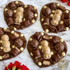 A selection of Heart-Shaped Chocolate Bars , topped with a Kinder Happy Hippo,Kinder Bueno, Ferrero Rocher and White and Milk Belgian Chocolate buttons.